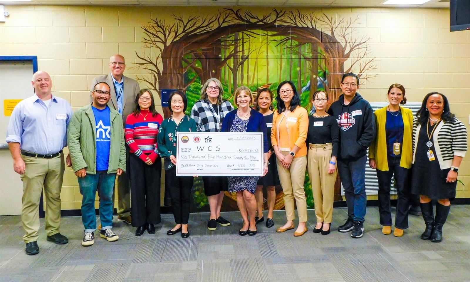 People stand with a large check